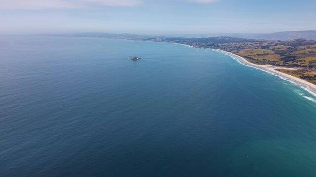 4k cinematic aerial drone footage of a tiny Island isolated in the big blue pacific ocean off the south island coastline of New Zealand near the city of Dunedin