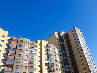 Modern brick apartment building with a balcony. Affordable housing, multi-unit city building, real estate, building facade.