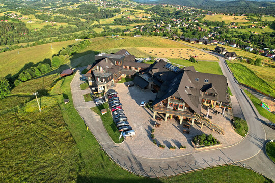 Aerial drone view of Hotel Zloty Gron Istebna at golden hour, landscape orientation, wide-angle composition, vivid natural lighting, panoramic resort brochure