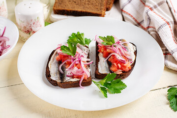 Sandwiches with anchovies, onions, and tomatoes. Diet meal. Delicious food