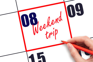8 th day of the month.  Hand writing Weekend trip reminder and drawing red frame on calendar with...