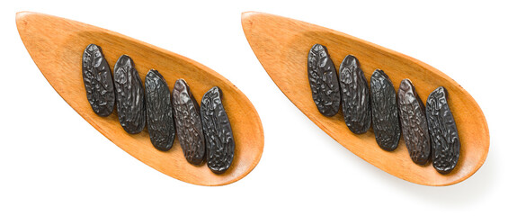 Tonka beans in the wooden plate, isolated on white background, top view.