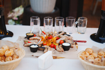 Delicious sausages and appetizers served at outdoor gathering on warm evening