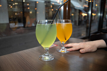 Kombucha. A refreshing kombucha drink with mango and apple flavors served in a beautiful glass with a straw. Served in restaurants and cafes.