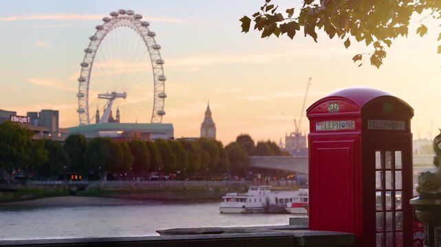 Beautiful autumn sunset view of the London skyline with a red telephone box and Big Ben tower in the background
