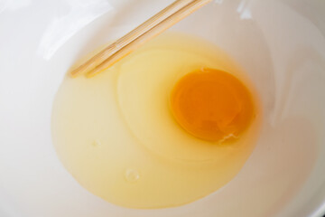 Whisking fresh egg yolk for baking kitchen food preparation indoor top-down view culinary art