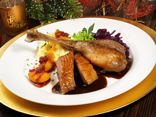 Roasted Christmas Goose on a golden Plate with Christmas Decoration