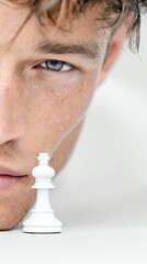 A close-up portrait of a thoughtful man contemplating strategy, with a chess piece reflecting focus and determination.
