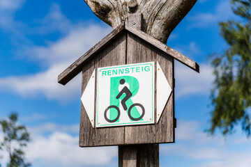 Weathered Wooden Sign for the Rennsteig Cycle Route with Blue Sky