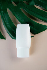 Cosmetic product in tube, bottle, lotion or serum with stylish props on light brown background. 