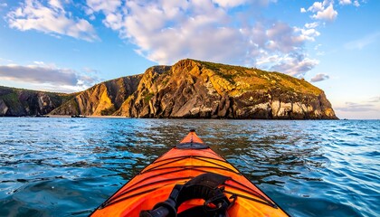 Kayaking towards a dramatic coastal outcrop at sunset.  Ocean view from inside a vibrant orange kayak