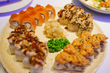Fresh sushi platters with colorful rolls and garnishes at a dining setting