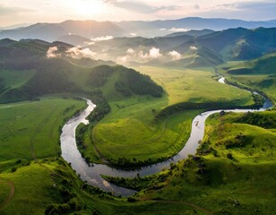 Lush valley river winds through rolling green hills, sunrise