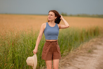Woman enjoying a summer day on a rural path surrounded by golden fields