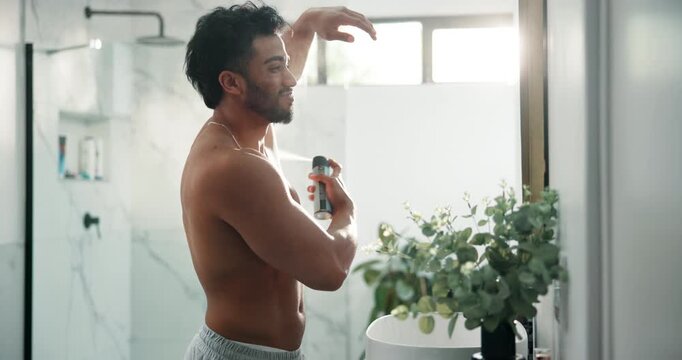 Man, shirtless and spray deodorant in bathroom for hygiene, smell fresh and grooming for odor control. Person, mirror and product for underarm fragrance, body cosmetics and sweat prevention at house