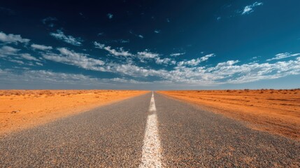 Fototapeta premium Desert Road Leading to Horizon Under a Dramatic Sky.