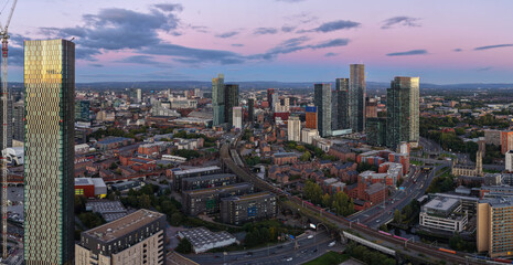 Aerial panorama of Manchester skyline at dusk with Trinity Islands towers, Castlefield viaduct, and...