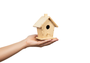 Isolated light wooden birdhouse rests in human hand, showing affection and care given
