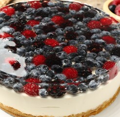 Delicious cheesecake with berries on table, closeup