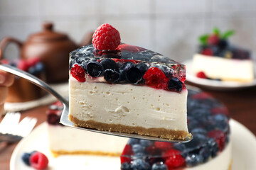 Cake server with piece of delicious berry cheesecake, closeup