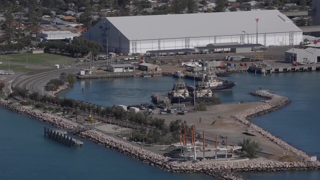 Aerial shot of a tugboat departing from its dock behind Geraldton esplanade.