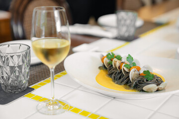 Elegant seafood pasta with white wine in modern restaurant lighting