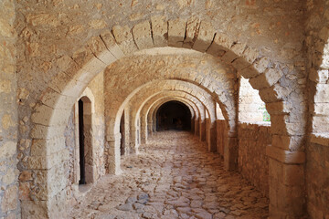 Beautiful stone arched corridor. Ancient architecture with warm natural light, textured stone walls and historic atmosphere.