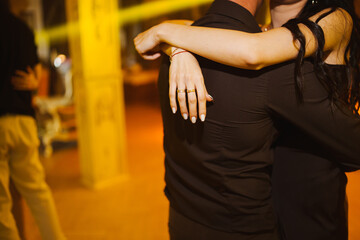 Couples enjoying a romantic dance in a softly lit outdoor setting at night