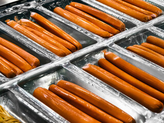 Sausages moving along a conveyor belt in a food processing facility