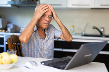 Elderly man describing symptoms to doctor during online consultation