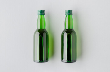 Fototapeta premium Miniature spirits, liquor bottle mockup, green glass.
