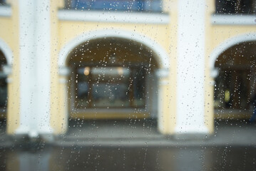 Rainy day view through a window. The raindrops on the glass for moody or reflective contexts, Posters or advertisements, Book covers or magazine spreads, Interior design inspiration, Social media
