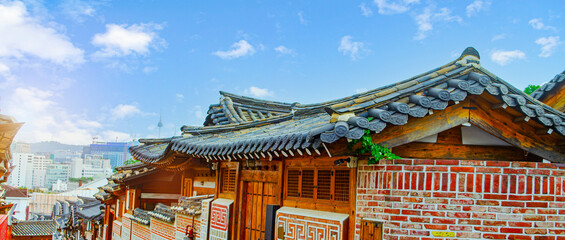 Panorama of Korean style roof at Bukchon Hanok Village on namsan tower background with sky cloud clear , Seoul, South Korea. holiday admire the architecture of traditional Korean houses
