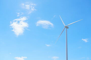 Fototapeta premium Wind turbine with clear blue sky background, symbol of clean energy, sustainability, renewable power, and green technology for an eco friendly and sustainable future.