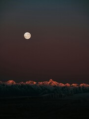 Full moonlit desert landscape with mountain silhouette at night sky dusk light