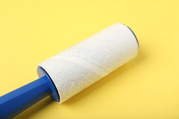 One lint roller on yellow background, closeup