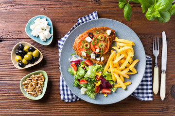 Breaded pork chop in tomatoes. Served with olives and feta cheese.