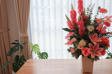 Elegant flower arrangement in a vase placed on a wooden table with soft sunlight and curtain background. Modern minimalist interior design concept showing natural beauty, cozy lifestyle, and home deco