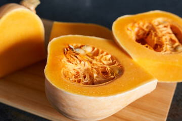 Butternut squash cut in half on wooden board, closeup