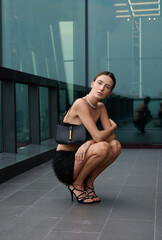 Naklejka premium Fashion shoot with a professional model, a girl on the roof of a building in stylish clothes.