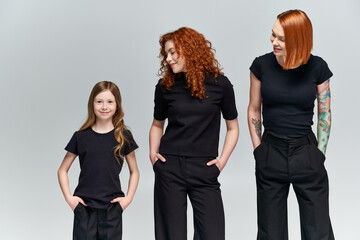 Three generations of red haired women celebrating family bonds in stylish autumn outfits