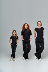 Fototapeta premium Three generations of red haired women enjoying autumn together in casual black attire