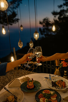 An elegant romantic dinner table set by the sea during sunset, featuring soft golden light, refined d&eacute;cor, and a tranquil seaside dining atmosphere. Ideal for romance, luxury hospitality, and destinat