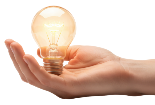 a brightly glowing vintage lightbulb is held in the open palm of a hand