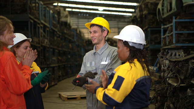 A diverse group of industrial workers wearing safety uniforms and helmets