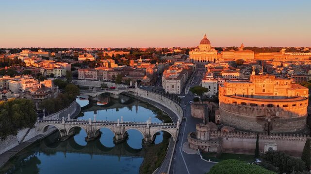 orbiting drone shot of river Tiber and Castel Sant Angelo in Italian capital Rome at sunrise, historic Roman architecture, aerial view of Sant Angelo bridge, travel in Rome
