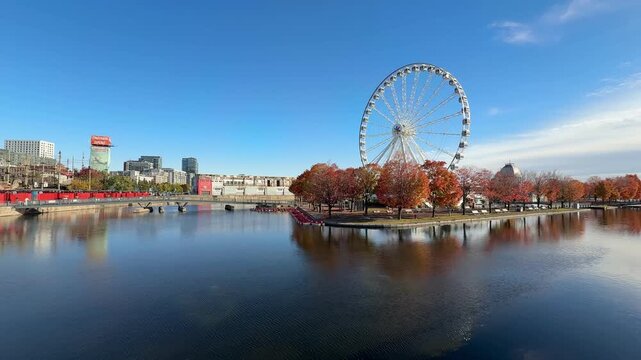 Montreal, Canada - October 08, 2025: Old Port in Montreal with its famous landmark, the Ferris wheel, during autumn, with bright yellow and brown leaves.