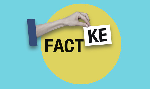 A hand holding a fake card with the word fact on it