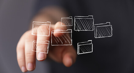 Person's finger touching virtual folders, representing file management, digital organization, and...