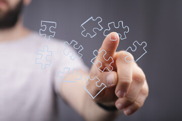 Hand pointing at puzzle pieces. Concept for solution, strategy, teamwork, and problem-solving.